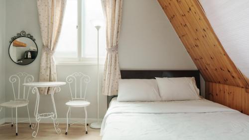 a bedroom with a bed and a table and chairs at Sokcho Maru Pension in Sokcho
