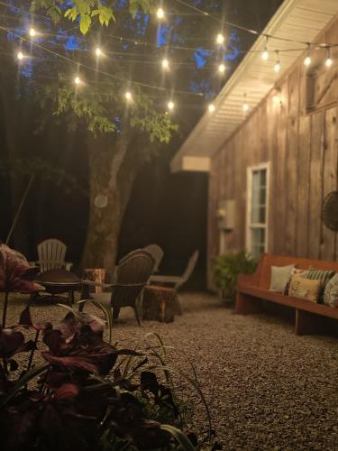 a patio with a couch and a tree and lights at The Little House at EVOO in Cookeville