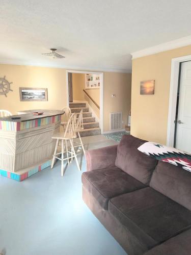 a living room with a couch and a kitchen and stairs at The Little House at EVOO in Cookeville