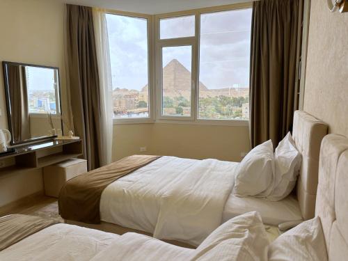 a hotel room with a bed with a view of the pyramid at Wonders Pyramids Hotel in Cairo