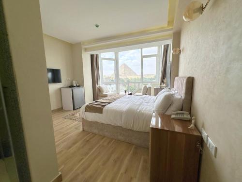 a hotel room with a bed and a large window at Wonders Pyramids Hotel in Cairo