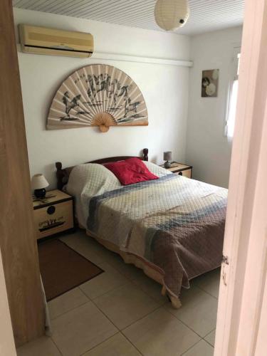 a bedroom with a bed with a wooden headboard at Villa Le Balisier in Le Lamentin