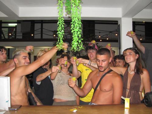 a group of people standing around a bar holding drinks at Gili Pirates Dive & Social Hostel in Gili Trawangan