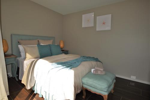 a bedroom with a bed and a chair in it at BeachBox Boutique Accommodation in Coopers Beach