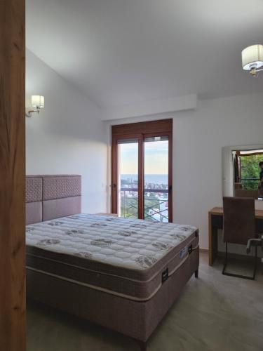 a bedroom with a bed and a desk and a window at Amd Ville Apartments in Dobra Voda