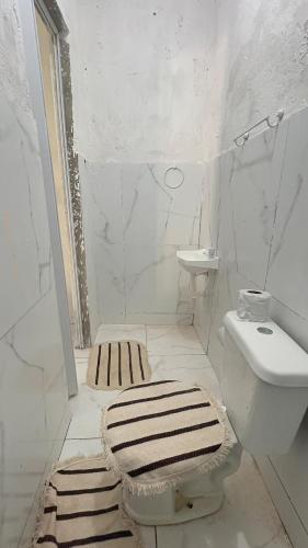 a white bathroom with a toilet and a sink at MT laser in São José da Coroa Grande