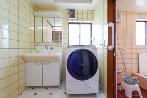 a bathroom with a washing machine and a sink at 湊の宿あまね in Hitachinaka