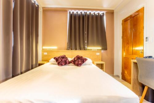 a bedroom with a large white bed with two pillows at Q-Inn Boutique Hotel in Paramaribo