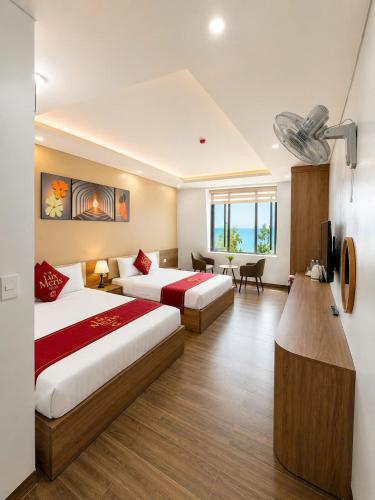 a hotel room with two beds and a desk at Lux Meris Hotel in Nhượng Bạn