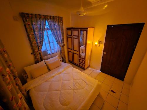 a small bedroom with a bed and a window at Wobbless Wonder Homestay in Bandar Seri Begawan