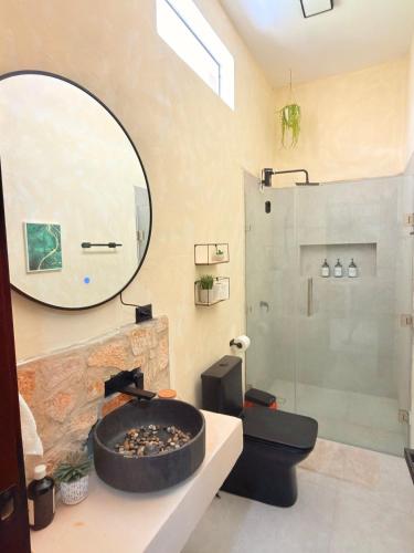a bathroom with a large circular mirror and a shower at Itza Living Apartments in Flores