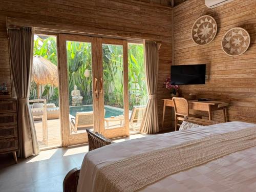 a bedroom with a bed and a view of a pool at Kubu Dimel Suites and Villas Resort in Nusa Dua