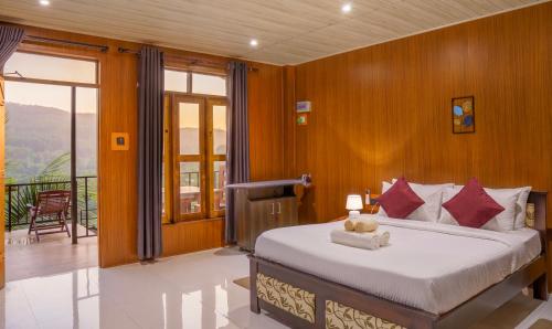 a bedroom with a bed and a balcony at Rock View Cottage in Ella