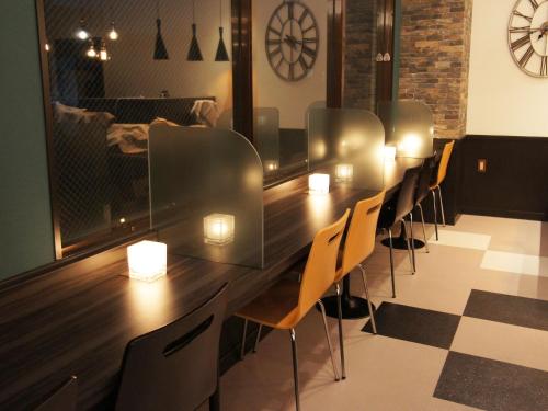 a long table in a room with chairs and a clock at Hotel AreaOne Nobeoka in Nobeoka