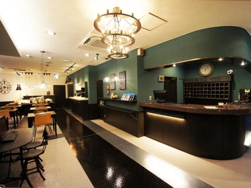 a restaurant with a bar with a clock on the wall at Hotel AreaOne Nobeoka in Nobeoka