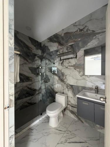 a bathroom with a toilet and a stone wall at Hotel Herradura in Herradura