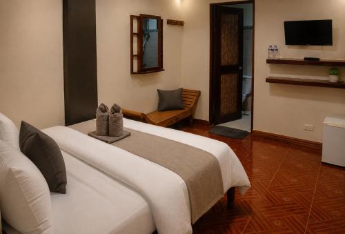 a hotel room with a bed and a television at LIV Coron in Coron
