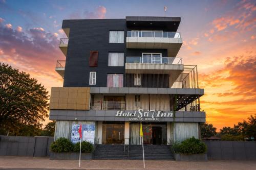 a building with a sunset in the background at Hotel Sree7 Inn in George Town
