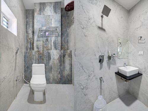 a bathroom with a toilet and a sink at Hotel Skyland Khammam in Khammam