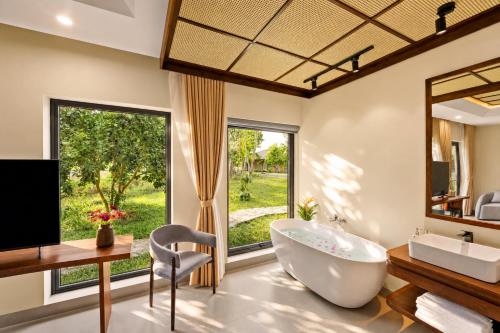 a bathroom with a tub and a large window at Cuc Phuong Tropical Villas in Thượng Sung