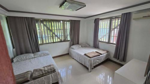 a bedroom with a bed and a couch and windows at Paradise Pacifica in Pacific Harbour