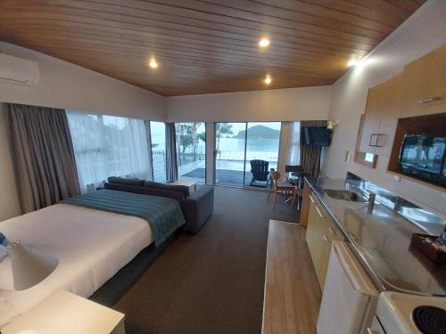 a bedroom with a bed and a desk and a television at Bayview Motel in Paihia