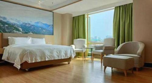 a bedroom with a large bed and a large window at Cheerful Hotel in Nanhai