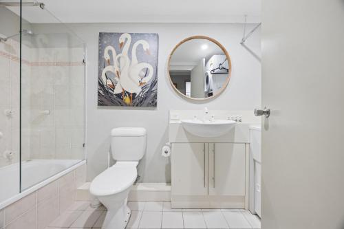 a bathroom with a toilet and a sink and a mirror at Horizons 404 in Jindabyne