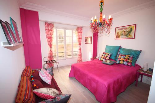 a bedroom with a pink bed and a couch at From Hollywood to Bollywood 2 Bedrooms 2 Bathrooms - 1 min from Croisette&Beach, 12 Min from the Palais in Cannes