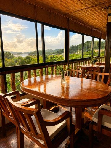 a table and chairs in a room with a view at LIV Coron in Coron