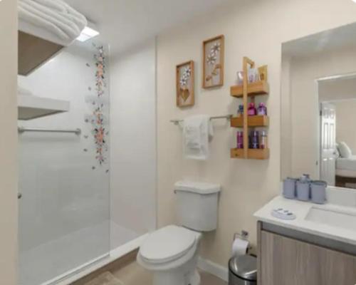a bathroom with a toilet and a sink and a shower at Deluxe suite in Portmore