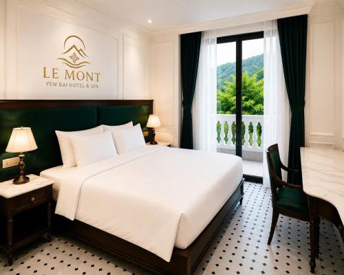 a bedroom with a bed and a desk and a window at Le Mont Yên Bái in Yên Bái
