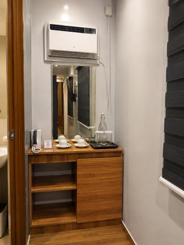 a bathroom with a vanity with a microwave and a mirror at Madigun Hotel and Events in San Francisco