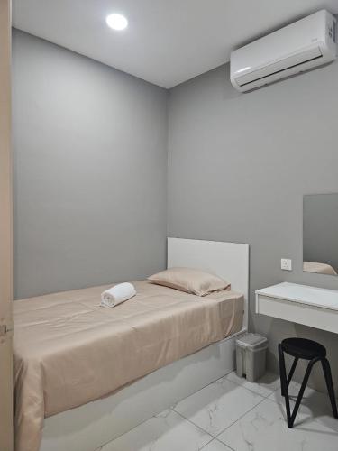 a white room with a bed and a desk at B&B By JumStay in Sepang