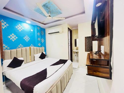 a bedroom with a bed and a television in it at Hotel Shyam Villa - Govindpuri Metro in New Delhi