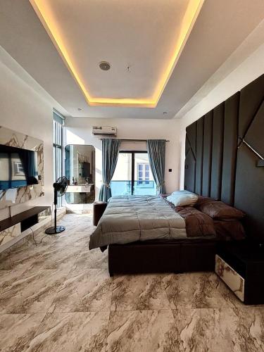 a bedroom with a large bed and a large window at Modern getaway in Ajah in Lekki