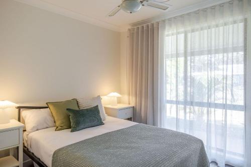 a bedroom with a bed and a large window at Narrawallee Nirvana in Narrawallee