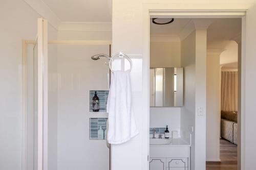 a bathroom with a shower with a white towel at Narrawallee Nirvana in Narrawallee