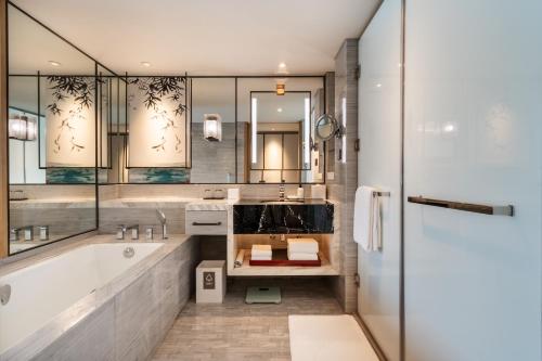 a bathroom with a tub and a sink at Grand Hyatt Hangzhou in Hangzhou