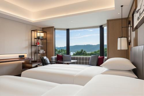 a bedroom with two beds and a large window at Grand Hyatt Hangzhou in Hangzhou