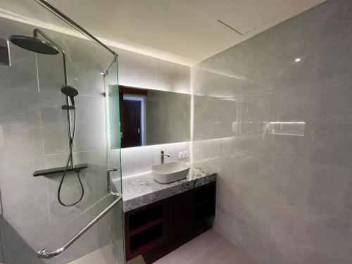 a bathroom with a sink and a glass shower at Taman Agung Hotel in Sanur