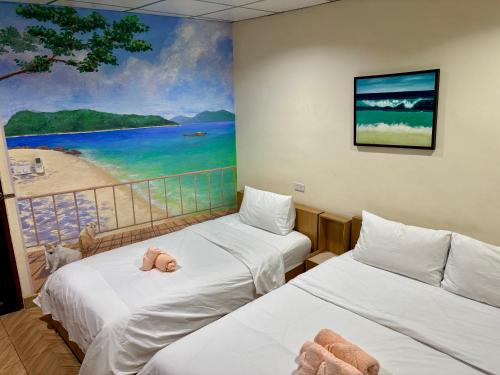 two beds in a room with a painting on the wall at Double D Rooms & Cafe in Bangkok