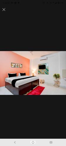 a bedroom with a large bed and a red rug at New Stay Hotel in Gurgaon