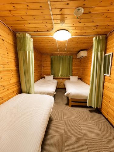 a room with four beds in a wooden cabin at Meteor Garden in Hakuba