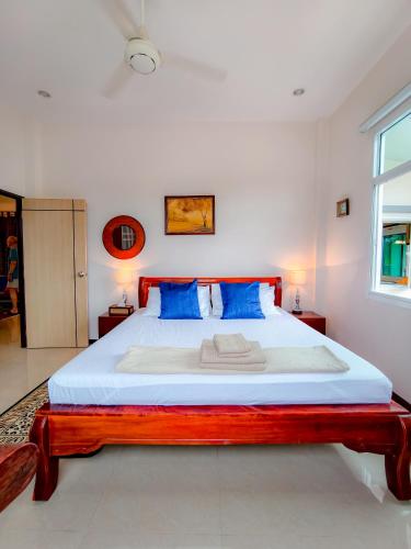 a bedroom with a large bed with blue pillows at Ped pool villa in Buriram