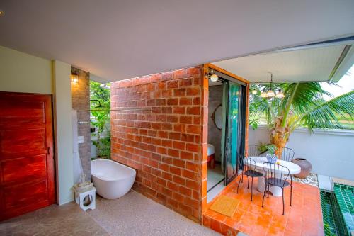 a bathroom with a brick wall and a sink and a tub at Ped pool villa in Buriram
