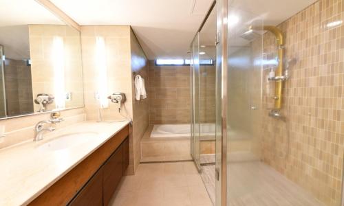 a bathroom with a shower and a sink and a tub at Jeju Tameus Golf & Village in Hahwajŏn