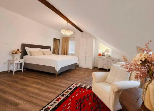 a bedroom with a bed and a couch and a chair at Garden Haus Livno in Livno