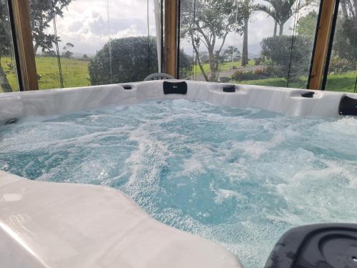 a jacuzzi tub in a room with water at Lanark Mews in Te Kopuru