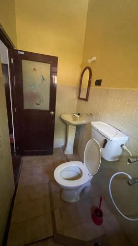 a bathroom with a toilet and a sink at Reefside mount villa in Deniyaya